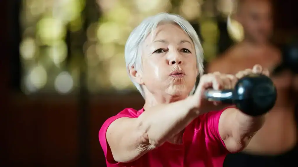 Older woman doing weight training Crawley to help her strength and longevity 