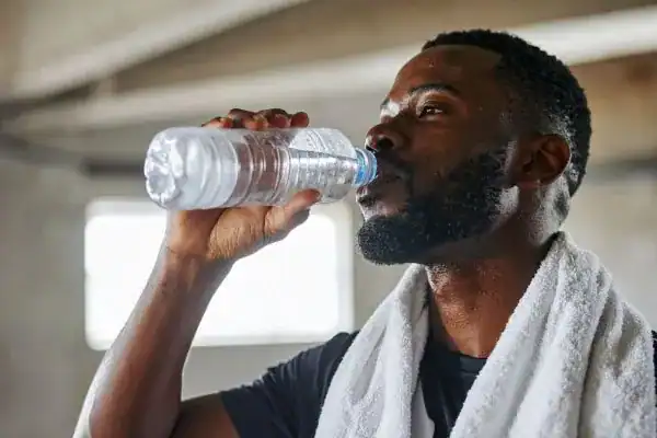 Hydration: The Secret Ingredient for a Toned Stomach and Enhanced Fitness 1 Image of man drinking water to improve hydration Crawley after work out.
